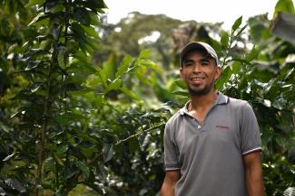 A Honduran coffee producer smiles at the camera