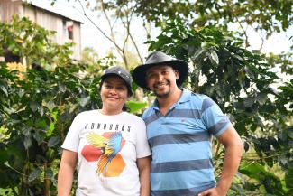 A couple of Honduran coffee producers smile at the camera.
