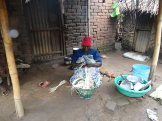 Asha Goa works outside her house in Tanzania.