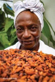 A smiling woman holds a large bowl of cacao