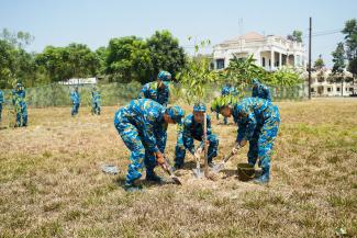 Vietnamese soldiers plant trees on a remediated parcel of land at Bien Hoa Air Base.