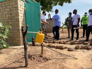 Inspecting a flood-resistant latrine construction, Digni-Loo with a nearby tippy-tap for handwashing