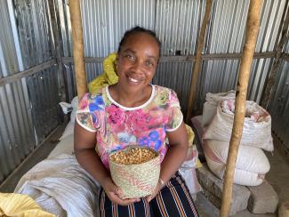 A seed vendor supplied by a USAID project, implemented by CRS in the southern village of Talaky-Bas, proudly displays her wares.