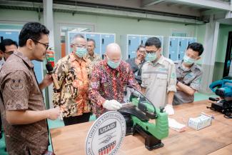 Direktur USAID Indonesia Jeff Cohen sedang mencoba mesin pengerjaan kayu di Maker Innovation Space bersama mahasiswa dan dosen ITB