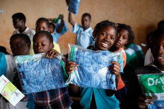 Children holding insecticide treated bednets