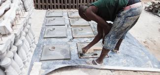 A mason constructing latrine concrete slabs in Bouaké, Côte d’Ivoire. 