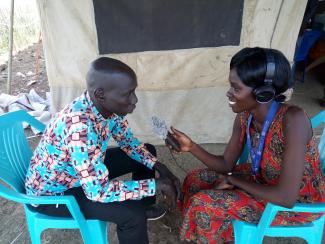 Nyajime Pekhoa Goak (right) with Kondial FM in Bentiu interviews a local resident.