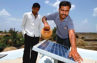 Representatives from Orb Energy in India prepare solar panels for installation