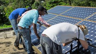 Technicians install a solar photovoltaic array