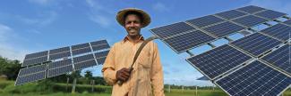 A farmer in Bangladesh poses in front of the solar photovoltaic arrays powering his irrigation pumps.
