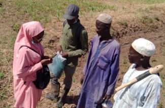 Hauwa trains men in the field about best practices in rice farming. Photo credit: WACOT Rice