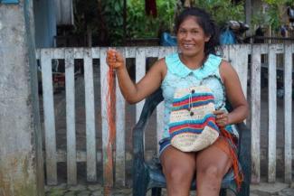 A woman holding natural fiber threads used to make artisanal bags