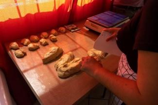 A woman's hands cutting the bread dough.