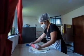 A woman in the kitchen preparing the bread dough