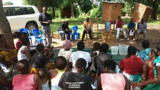 Mr Ligowe, USAID representative briefing gathered communities on the importance of drinking safe water to prevent and control cholera in Karonga