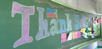 Chalkboard reading "thank you, USAID"