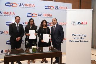 USAID & USISPF representatives standing together with signed MOU