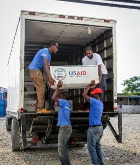 Workers offload relief commodities at a warehouse in Port-au-Prince, Haiti, during USAID's Hurricane Matthew response.