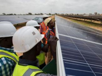 Inspecting solar solar panels at the Power Africa-supported Senergy I solar plant, a 29 MW facility that is currently the largest solar farm in West Africa. 