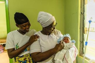 Adama holds a newborn baby boy her patient gave birth to just four hours prior.