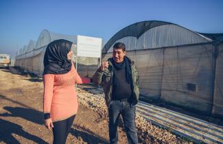 Osama Abu Al-Rub walks and talks to his daughter Hanin at their strawberry farm in Qabatiya, in Jenin Governorate, Palestine.
