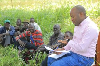 ResilientAfrica Network’s Director Operations and Co-Investigator Julius Ssentongo visits with a group of Indigenous men in Uganda.