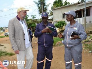 Agents from the power company on the field with former USAID Mission Director 