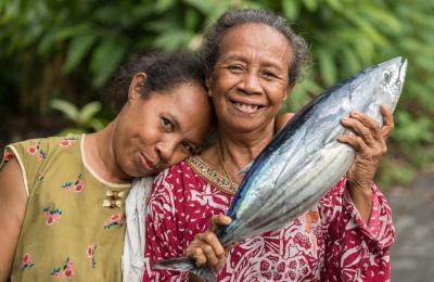 Cheerful Woman showed fresh Skipjack fish in Banda Neira, Maluku islands.
