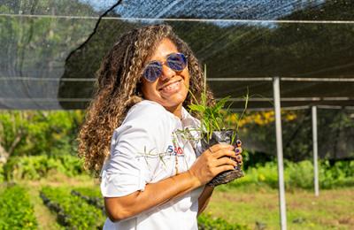 Marlí Tamayo, Local Works Project Management Specialist, stands outside in a garden during a site visit to the Northwest region of the Dominican Republic.