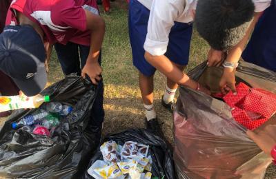 two students sort through trash to be recycled