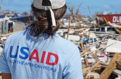 A USAID Dart team member assess damage. Click to view What We Do