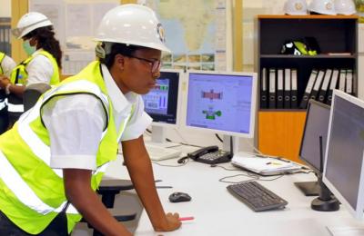 A female engineer works at a control terminal in the operations center of a hydropower plant in Liberia.