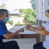 Nurse Le Thi Cam Giang is consulting with Mr Vu on his weekly visit to get TB drugs at An Tinh commune health centre.