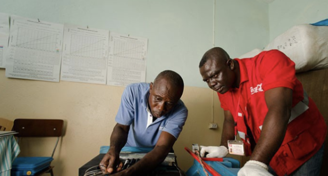 Coca-Cola and Health Service Technician repair vaccine refrigerator in Ghana | Photo courtesy of PLM