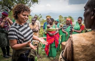 USAID Measuring Impact Conservation Enterprise Retrospective (Uganda; International Gorilla Conservation Program) September 2017. Salvatrice Musabyeyezu, International Gorilla Conservation Program (IGCP) Tourism Specialist talking with the Batwa about their tourism program. The Batwa were evicted from their home lands in the forest in the early 1990s when the Mgahinga Gorilla National Park was established. Mgahinga Gorilla National Park, Uganda.